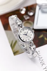 Details der silbernen Herz-Kristall-Armbanduhr mit blauen Zeigern und weißem Zifferblatt