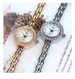 Détail de montres à quartz or rose et argent avec lunette en strass et bracelet en métal