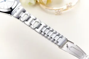 Detailed close-up of polished silver stainless steel watch strap and sleek white watch face