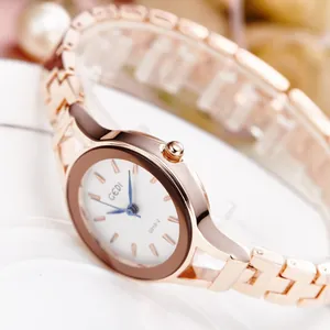 Detailed close-up of GEDI rose gold watch with blue hands and white textured dial