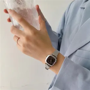 Montre carrée pour femme avec bracelet milanais argenté et cadran sombre au poignet