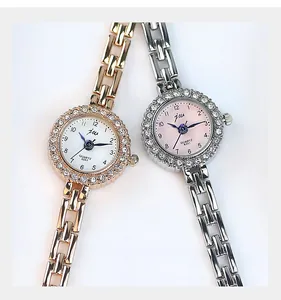 Gros plan de montres à quartz élégantes avec lunette en strass et bracelet métallique