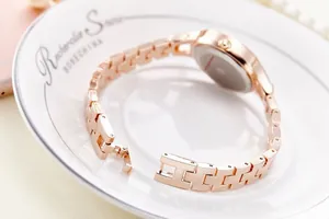 Macro detail of rose gold steel link bracelet and clasp of a fashionable ladies watch