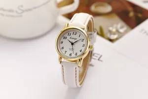 Close-up of elegant white leather strap watch with gold case and Arabic numerals dial