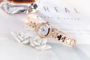 Detail of rose gold quartz watch with rhinestone markers and stylish chain strap