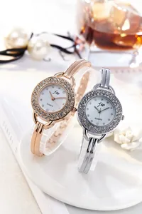 Close-up of elegant rose gold and silver quartz watches with sparkling rhinestone bezels