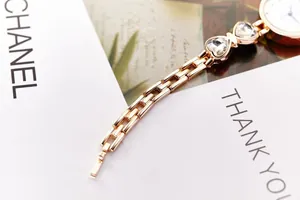 Detailansicht der Roségold-Quarzuhr mit Kristallherzen auf eleganter Geschenkkarte