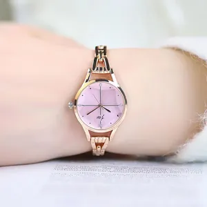 Détail d'une montre or rose avec cadran rose et strass sur bracelet métallique fin