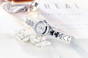 Close-up of women's silver quartz watch featuring an H-shaped metal chain strap