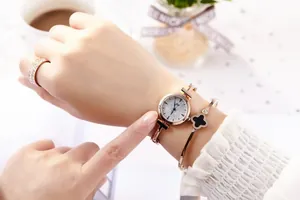 Close-up of rose gold watch set with starry sky dial, clover bracelet and ring