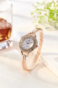 Close-up of rose gold ladies' watch with rhinestone bezel on a sleek bracelet strap