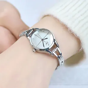 Montre bracelet chaîne argentée élégante pour femme avec cadran blanc portée au poignet