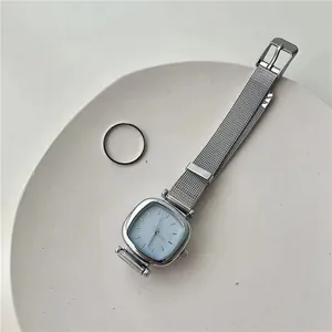 Vue détaillée de la montre carrée minimaliste avec bracelet en maille argentée et cadran bleu