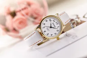Elegant gold quartz watch with white leather strap on a decorative thank you card