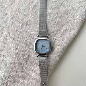 Détails de montre carrée argentée avec cadran bleu clair et bracelet en maille d'acier