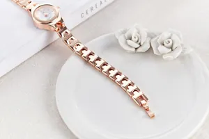Detailed macro of rose gold quartz watch with metal chain strap and white dial