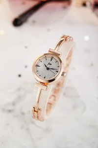 Close-up of rose gold watch with T-bar lugs and starry textured grey dial details