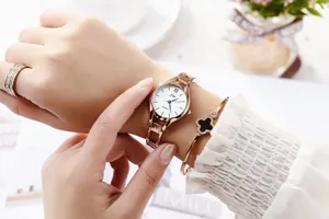Rose gold women's watch set featuring a white dial, sparkling ring, and clover bracelet