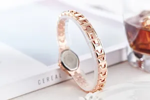 Macro view of a rose gold fashion watch with elegant H-shaped metal chain links