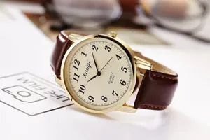 Detailed 45-degree angle of a vintage gold quartz watch with a brown leather strap