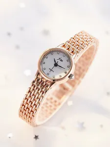 Detailed macro view of the rose gold mesh band and crystal index on women's quartz watch