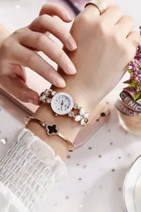 Détail d'une montre à quartz blanche avec bracelet floral et jonc trèfle au poignet