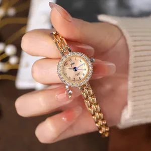 Montre quartz dorée élégante pour femme avec lunette en strass et bracelet en acier