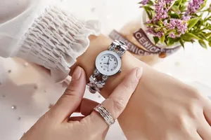 Détail d'une montre à quartz fleur en argent avec bracelet strass et bague assortie