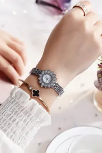 Detailed shot of silver rhinestone watch and gold clover bracelet set on a wrist