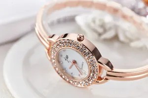 Detail of rose gold bracelet watch with sparkling crystal-set bezel and elegant JW logo