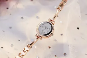 Close-up of rose gold watch case back with stainless steel engraving and chain strap