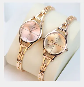 Détail du bracelet en métal or rose et cadran minimaliste sur support de montre
