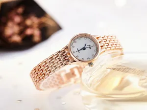 Detail of rose gold bracelet watch with quartz movement and crystal hour markers