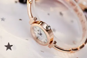 Macro view of rose gold bracelet watch with sparkling dial on soft star pattern veil