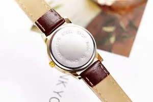 Detail of the stainless steel back case and brown textured leather strap on a quartz watch