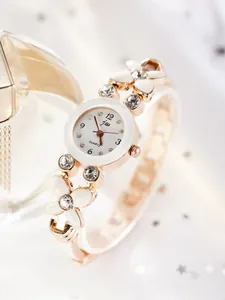 Détail du bracelet montre fleur en or rose avec strass brillants et cadran à quartz