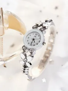 Détail d'un bracelet de montre en argent avec fleurs en strass et cadran à quartz