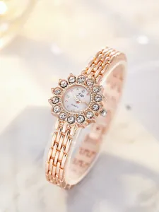 Detailed close-up of rose gold watch dial with sunflower rhinestone bezel and metal chain