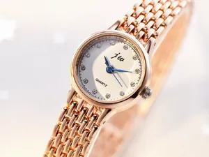 Close-up of rose gold mesh band watch with ivory dial and crystal hour markers