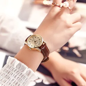 Retro quartz watch with gold metal case, champagne dial, and brown leather strap for women