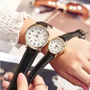 Elegant gold couple quartz watches with white dial and black leather straps on wrist