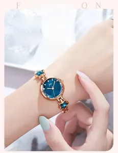 Detail of rose gold fashion watch with navy blue starry dial worn by a female model