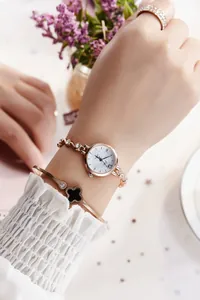 Montre femme or rose avec bracelet strass et jonc trèfle noir porté par un mannequin