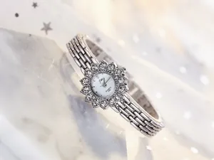 Macro view of luxurious silver ladies watch dial with radiant sunflower rhinestone setting