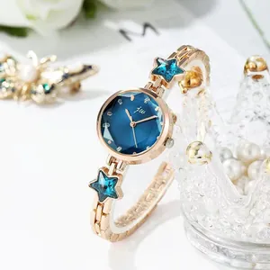 Detail of rose gold watch with blue star crystals and navy blue sunray dial texture