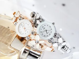 Détails macro de montres bracelets à fleurs or rose et argent avec strass brillants