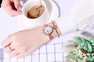 Gros plan d'un coffret montre femme or rose avec bracelet étoile et bagues élégantes