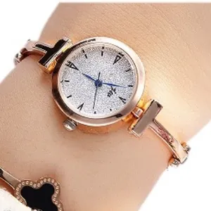 Women's rose gold watch with star-dial and clover bracelet set on wrist