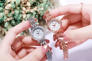 Makroansicht von Quarzuhren mit Strasszifferblatt und Armbändern in Silber und Roségold