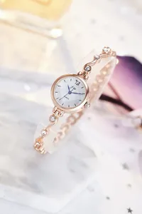 Vue détaillée du cadran rose doré à motif quadrillé et bracelet chaîne serti de diamants